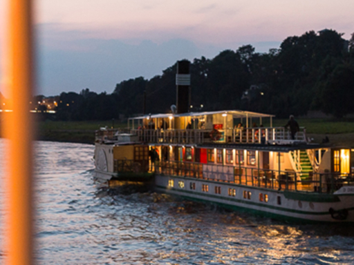 Abendliche Schlösserfahrt mit Dixie-Swing Steamers pass near the Waldschlößchen Bridge. A band plays on the sundeck of one of the ships, while passengers listen.