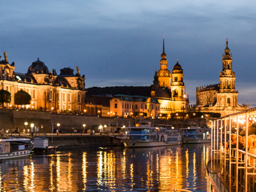 Abendbrotschiff Steamer in the evening, illuminated and in the background the illuminated old town. There are many people on board.