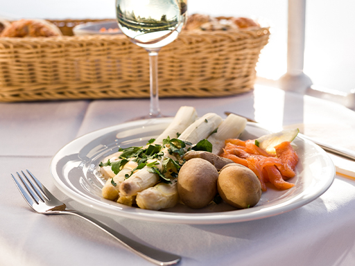 Ein Glas Wein und im Hintergrund ein Brotkorb.