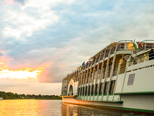 Ein Salonschiff fährt auf der Elbe. Auf dem Sonnendeck wird eine Party gefeiert. Es ist früher Abend, die Sonne geht bald unter.