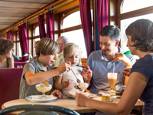 Eine Familie isst Eisbecher im Salon eines Dampfers.