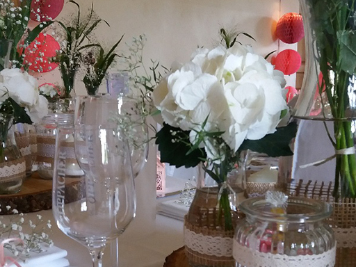 Ein festlich gedeckter Tisch mit Gläsern und weißen Blumen.