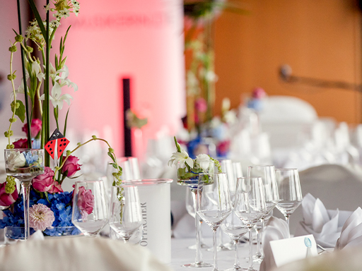 Ein Tisch mit vielen Gläsern, Blumen und Servietten.