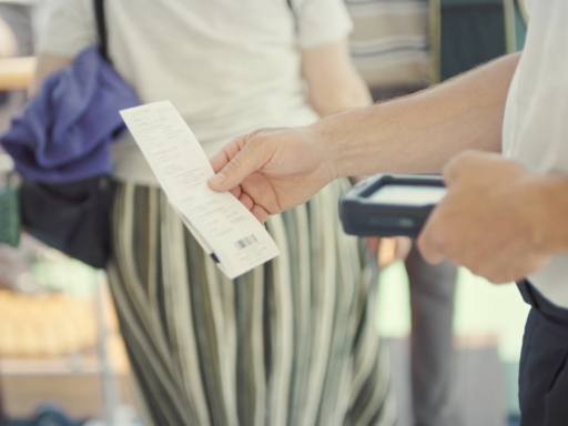 Beim Zustieg auf einem Schiff wird ein Ticket gescannt. Ein Mitarbeiter hält mit der linken Hand den Scanner und mit der rechten Hand das Ticket.