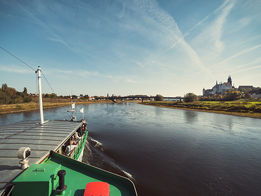 Ein Dampfer fährt elbaufwärts und erreicht in wenigen Minuten Meißen. Rechts im Bild ist die Albrechtsburg zu sehen. Es ist sonnig, voraus spannt sich die neue Meißner Elbbrücke über den Fluss.
