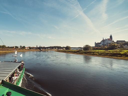 Ein Dampfer fährt elbaufwärts und erreicht in wenigen Minuten Meißen. Rechts im Bild ist die Albrechtsburg zu sehen. Es ist sonnig, voraus spannt sich die neue Meißner Elbbrücke über den Fluss.