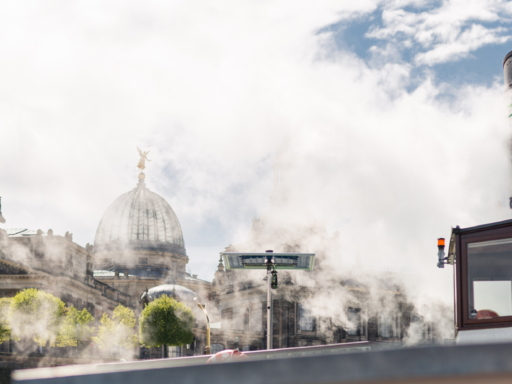 Ein Dampfer vor dem Terrassenufer. Weißer Qualm steigt auf und zieht Richtung Ufer. Im Qualm zu erkennen sind die Brühlsche Terrasse und die Kuppel der Kunstakademie.