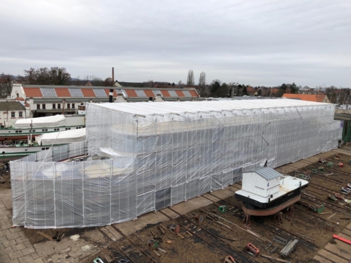 WhatsApp Image 2024-02-02 at 14.13.36 Aerial view of a saloon boat at the shipyard. The ship is scaffolded and the scaffolding is covered with foil.