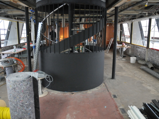 2024-03-22-Umbau Cosel aktueller Stand Panorama Bar Im Vorderteil eines Motorschiffs ist bereits die erneuerte Wendeltreppe vom Hauptdeck zum Oberdeck fertig. Sie ist mattschwarz lackiert. Erste Wanddämmungen sind zu sehen, Filzmatten stehen bereit.