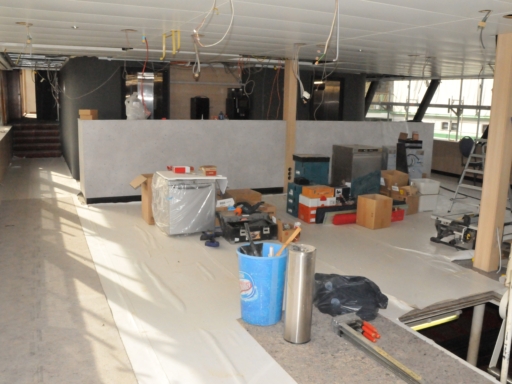 Bild vom Innenausbau des Motorschiffs Gräfin Cosel. Im künftigen Conference Deck sind die Deckenplatten schon eingesetzt. Kabel hängen herunter. Der neue Fußbocenn ist mit Planen geschätzt. Einrichtungsgegenstände und Werkzeug stehen im Raum.