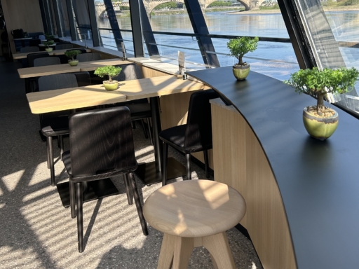 image00023 Blick vom Panoramaplatz an der Front der Panorama Bar eines Motorschiffs in den Raum. Die helle Bar hat eine schwarze Tischplatte, davor steht ein Hocker.