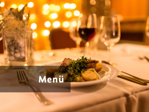 Ein Teller mit einem angerichteten Essen, dahinter steht ein Glas Rotwein.