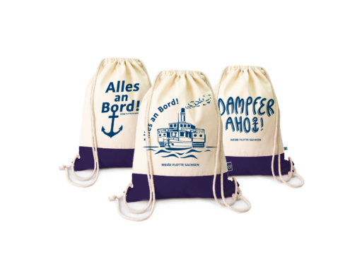 Drei Souvenir-Rucksäcke der WEIßE FLOTTE SACHSEN GmbH mit verschiedenen Motiven, unter anderem einem stilisierten Dampfer.